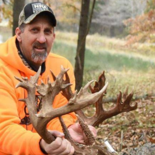 a man holding a deer: buck.png
